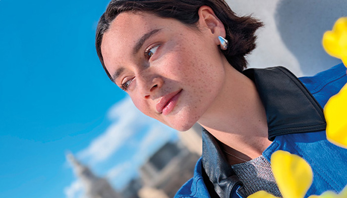 il viso di una ragazza con capelli neri e corti e una giacca blu/nera