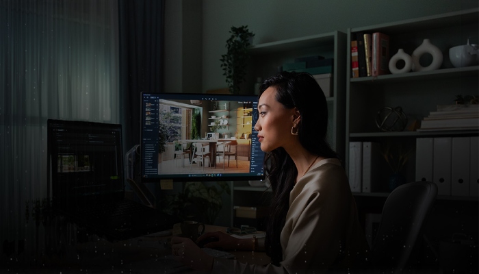 donna lavora al computer con due schermi nella sua cameretta/studio