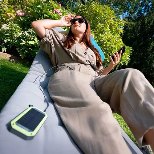 una donna mentre mette sotto carica il suo smartphone