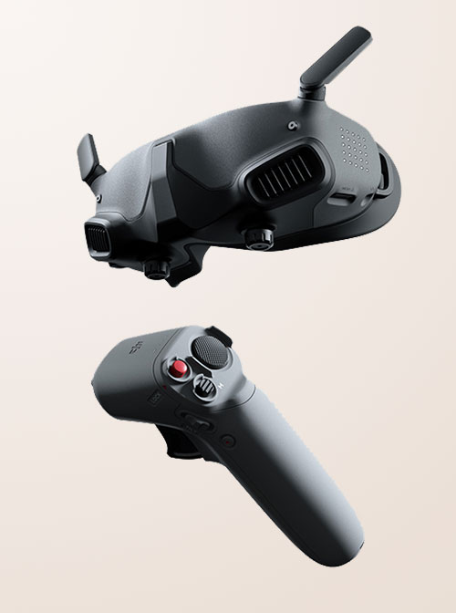 Occhiali FPV neri con antenna e controller grigio con pulsanti su sfondo neutro.