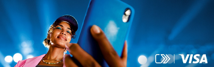 Donna che guarda lo smartphone sorridendo, sullo sfondo luci.