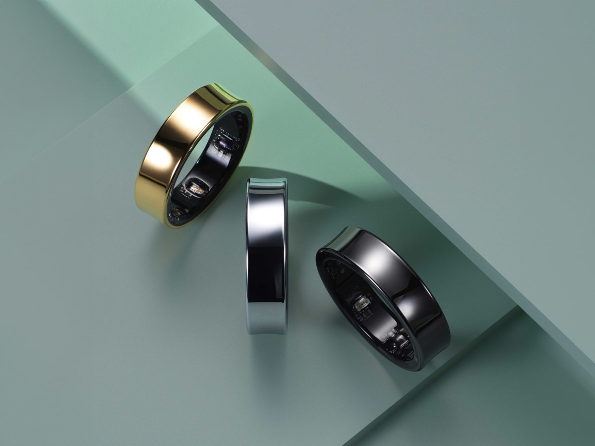 Tre anelli su sfondo verde: uno oro, uno argento e uno nero.