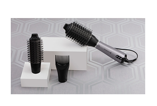 Spazzola rotonda, accessorio a rullo e pettine nero su sfondo grigio con motivo a nido d'ape.