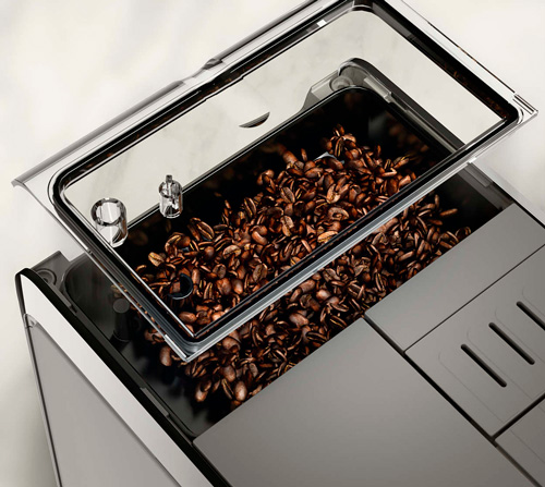 Contenitore di chicchi di caff� marroni in macchina da caff� grigia con coperchio trasparente.