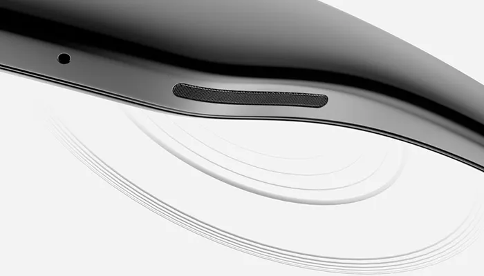Primo piano di un dispositivo nero con griglia dell'altoparlante e cerchi bianchi sullo sfondo.