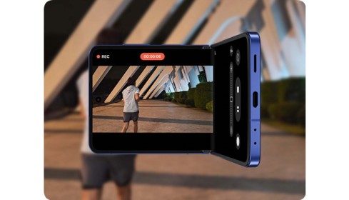 una foto sfocata di un ragazzo nello sfondo e la stessa foto ripresa da un telefono samsung galaxy flip7 blu