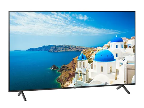 Schermo TV nero con vista su mare, case bianche con cupole blu e montagne.