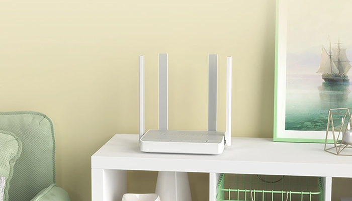 Router bianco con quattro antenne su scaffale bianco. Sullo sfondo, parete chiara e quadro con barca a vela.