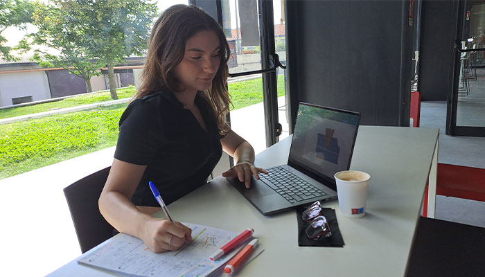 una studentessa intenta a scrivere mentre lavora con un notebook