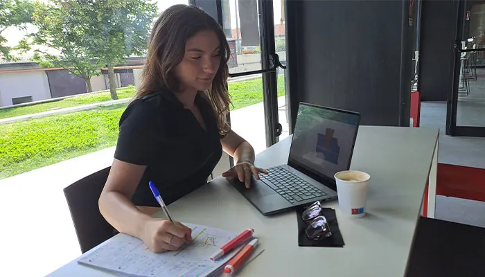 una studentessa intenta a scrivere mentre lavora con un notebook