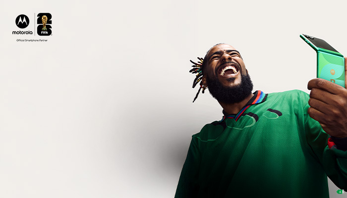 uomo che ride tiene in mano un telefono motorola