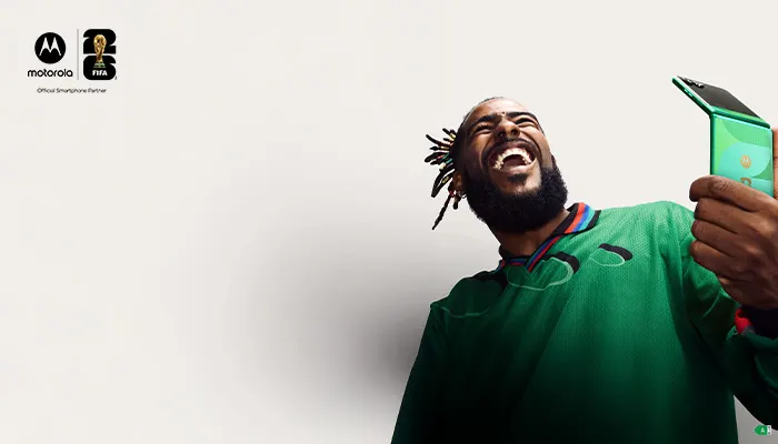 uomo che ride tiene in mano un telefono motorola