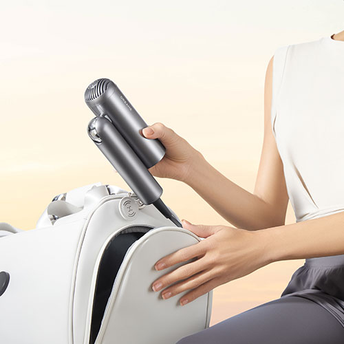 Donna che ripone phon grigio in borsa bianca. Sfondo beige chiaro.