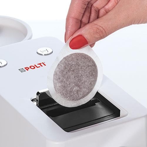 Mano inserisce cialda di caff� in macchina bianca Polti. Dettagli neri e pulsanti argento.