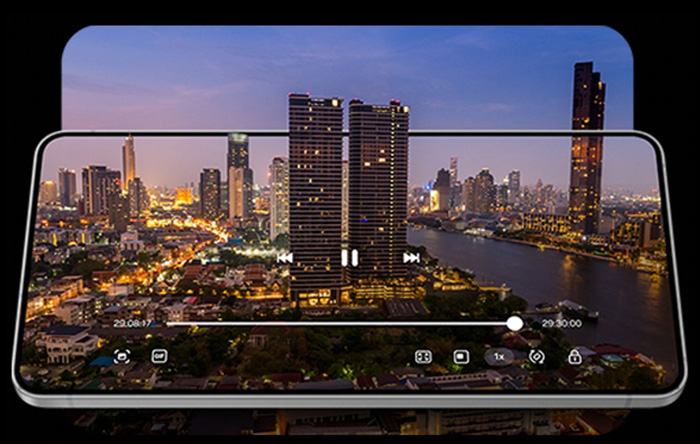 Schermo di smartphone che mostra un video di uno skyline di città con grattacieli e un fiume al crepuscolo.