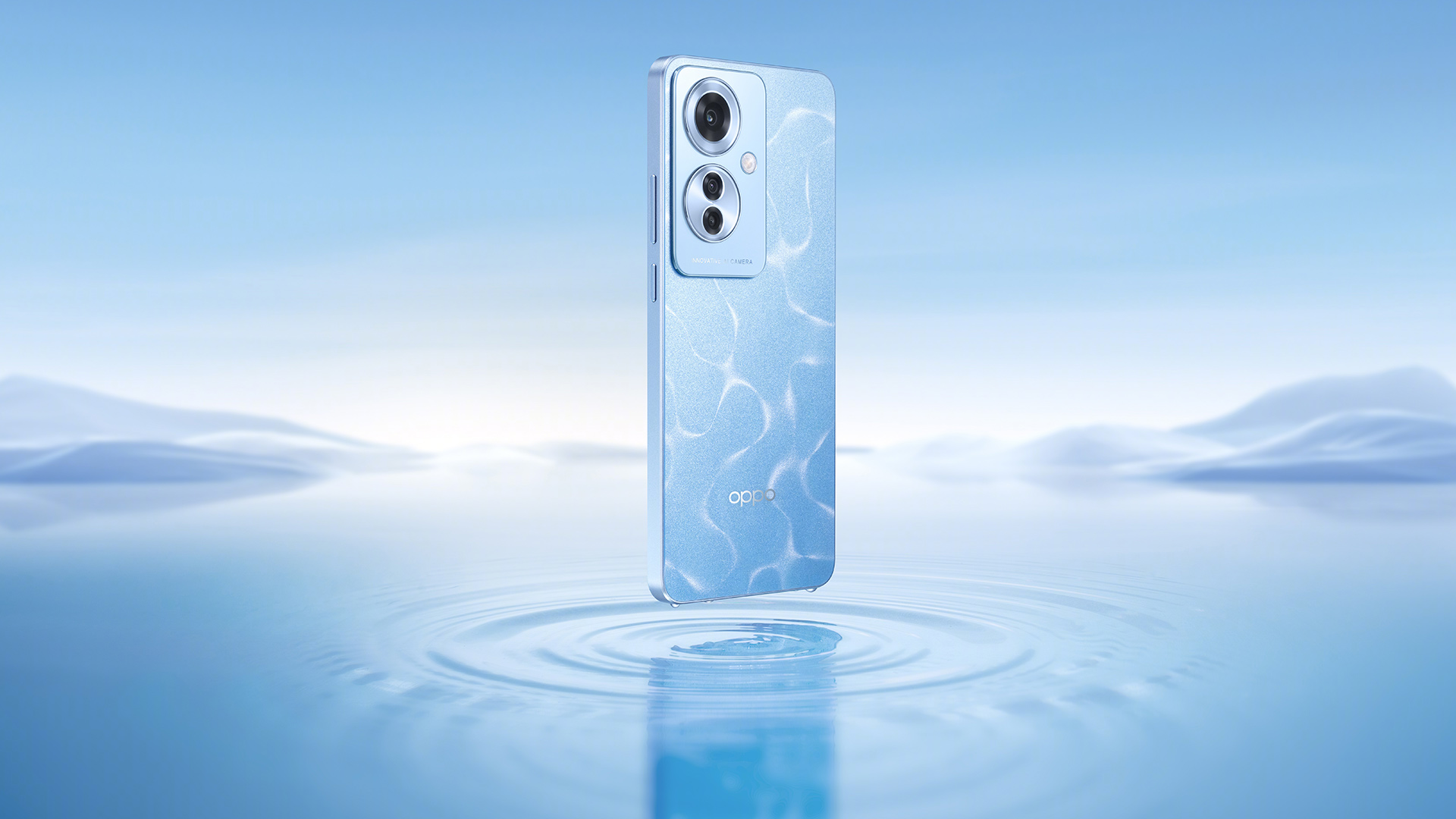 Un telefono azzurro con doppia fotocamera fluttua sopra l'acqua con increspature concentriche su uno sfondo azzurro sfumato.