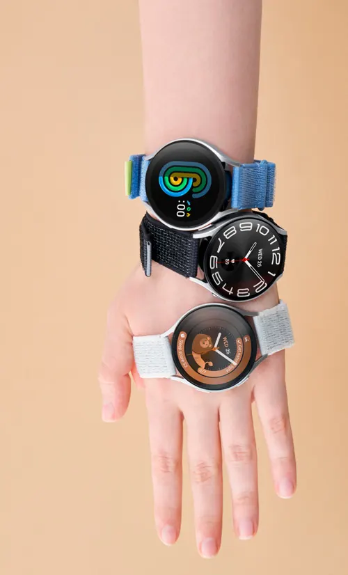 Una mano con tre orologi da polso impilati. I cinturini sono blu, nero e bianco. Gli schermi degli orologi mostrano diversi display.