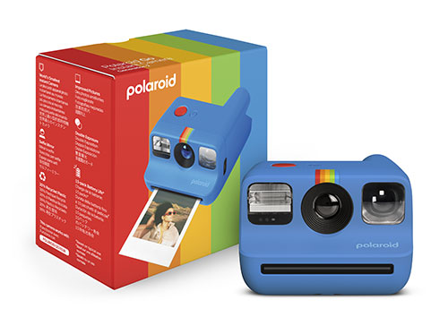 Due fotocamere Polaroid azzurre con confezione rossa e arcobaleno. Una foto stampata mostra una persona.