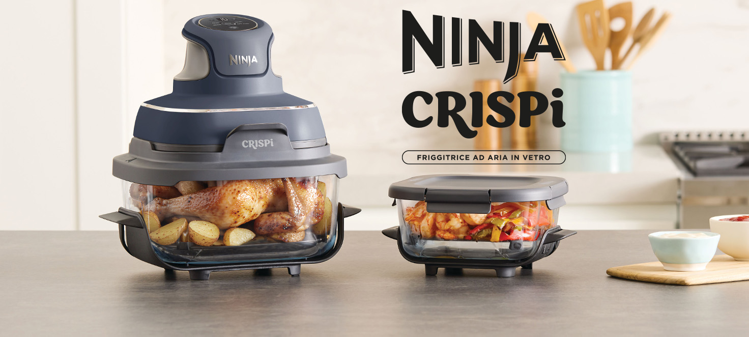 Banner pubblicitario Ninja Crispi che mostra la friggitrice ad aria in vetro blu scuro con un pollo intero e patate in cottura, e un contenitore ermetico con verdure accanto.