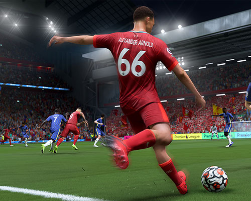 Stadio con giocatore in maglia rossa che calcia un pallone da calcio. Altri giocatori e pubblico sullo sfondo.