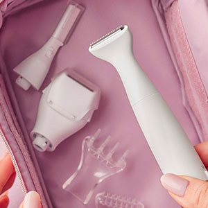 In un beauty case rosa sono presenti un rasoio bianco e accessori per la pulizia del viso in plastica trasparente.