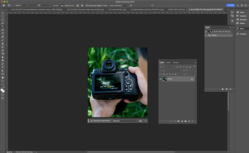 Interfaccia di Photoshop con fotocamera DSLR nera tenuta in mano, sfondo verde e pannelli degli strumenti aperti.