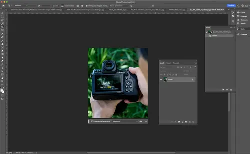 Interfaccia di Photoshop con fotocamera DSLR nera tenuta in mano, sfondo verde e pannelli degli strumenti aperti.