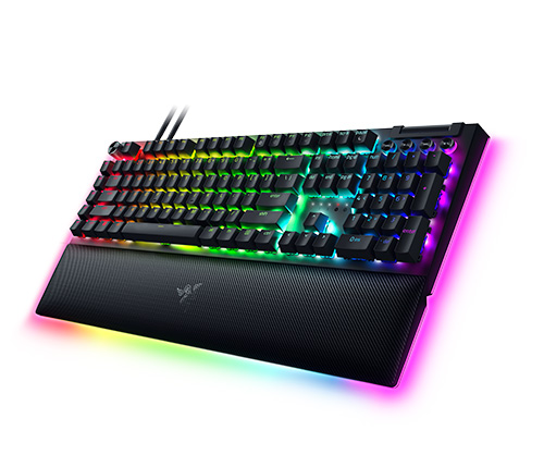 Tastiera nera retroilluminata con poggia polsi su sfondo bianco. Le luci sono colorate con effetto arcobaleno.