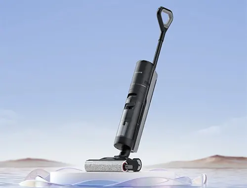 Aspirapolvere verticale scuro con manico ad anello, poggia su una superficie bianca con sfondo celeste.