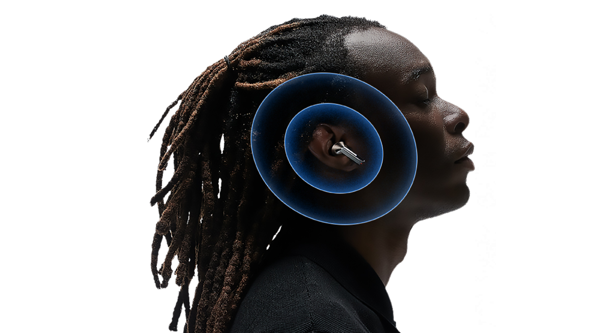 Uomo di profilo con dreadlocks, indossa auricolare. Cerchi blu concentrici intorno all'orecchio. Sfondo bianco.