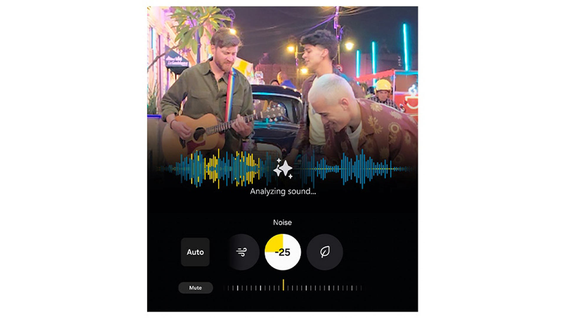 Tre persone suonano musica all'aperto. Un uomo suona la chitarra. Interfaccia di riduzione del rumore in sovrimpressione.