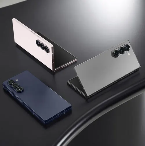 Tre smartphone con tre fotocamere sono su una superficie scura. Uno è bianco, uno grigio e uno blu scuro.