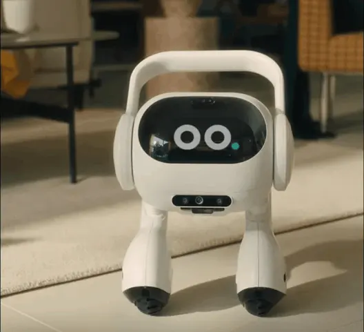 Robot bianco con occhi neri e maniglia, su pavimento chiaro. Sfondo sfocato con mobili.