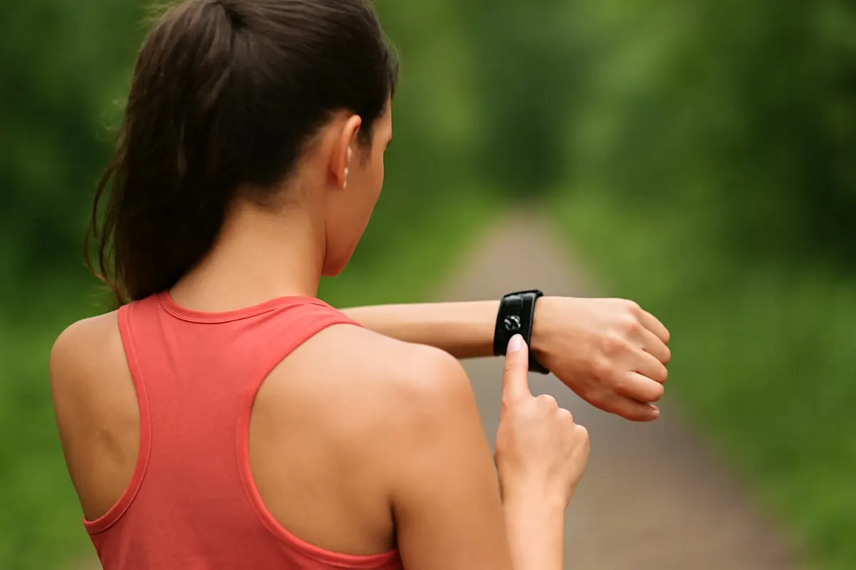 ragazza che fa footing al parco indossando un fitness tracker