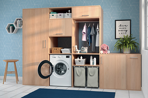 Lavanderia con lavatrice aperta, armadio in legno, cesto biancheria, sgabello e decorazioni su parete azzurra.