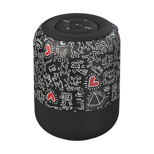 Cassa bluetooth cilindrica nera con disegni bianchi e cuori rossi. Parte superiore e inferiore nere, liscia la prima e a griglia la seconda.
