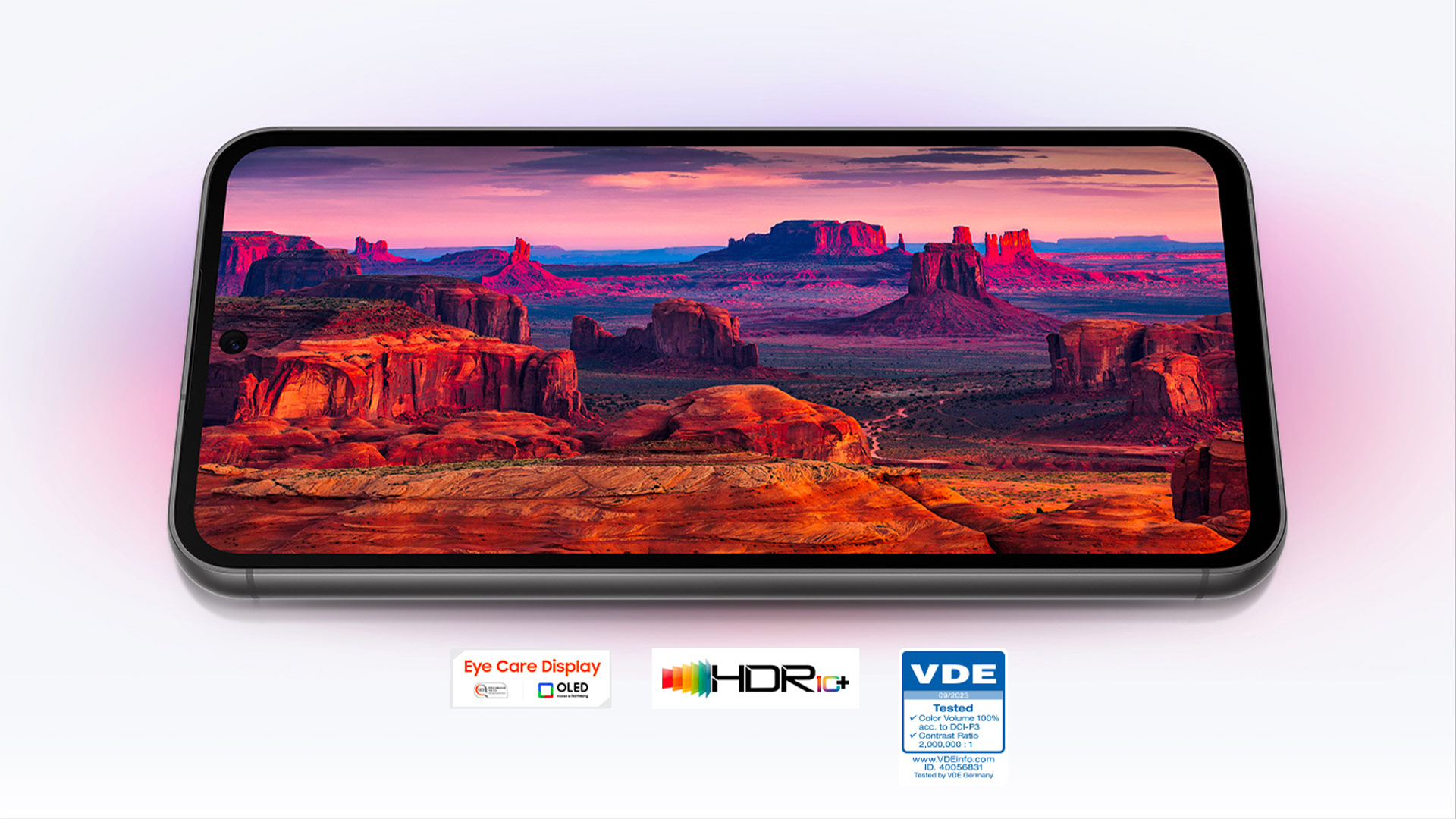 Smartphone con display che mostra un paesaggio desertico con formazioni rocciose rosse sotto un cielo rosa e viola.