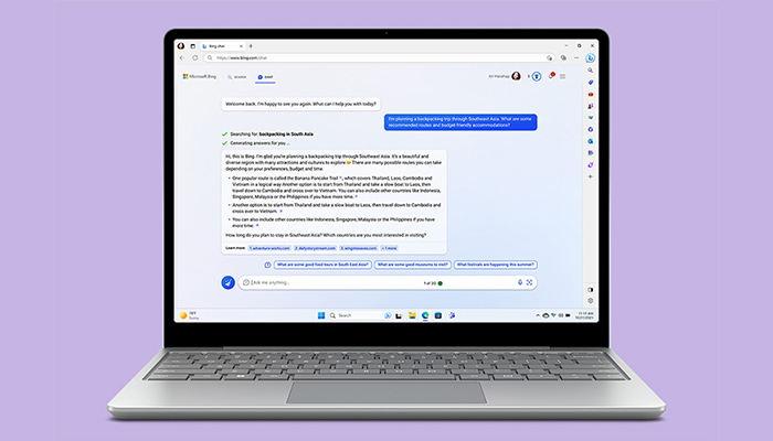 Un laptop aperto su una pagina web mostra un'interfaccia di chat con testo su sfondo lilla.