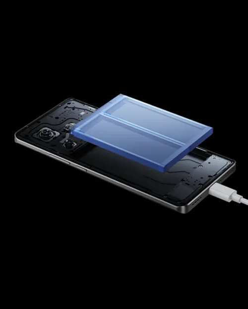 Un telefono nero è collegato a un caricabatterie bianco con un blocco di ghiaccio blu sulla parte superiore. Sfondo nero.