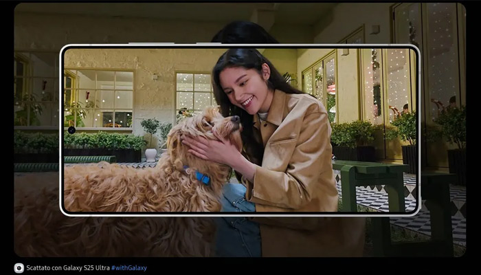 Donna sorride mentre accarezza un cane marrone. La scena è inquadrata in un telefono su uno sfondo scuro.