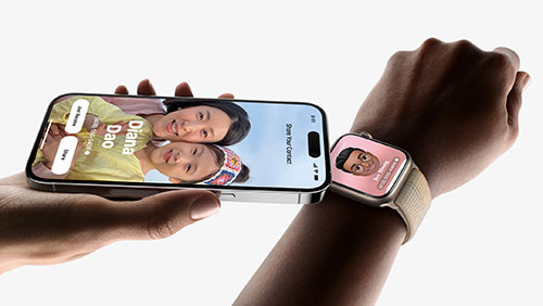Mano tiene un iPhone che mostra una foto di due persone; un orologio da polso mostra un'altra foto. Lo sfondo � bianco.