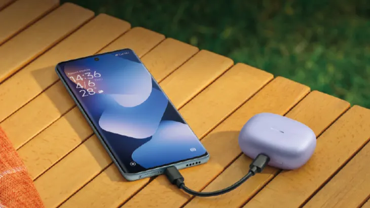 smartphone collegato a cuffie con cavo su tavolo di legno