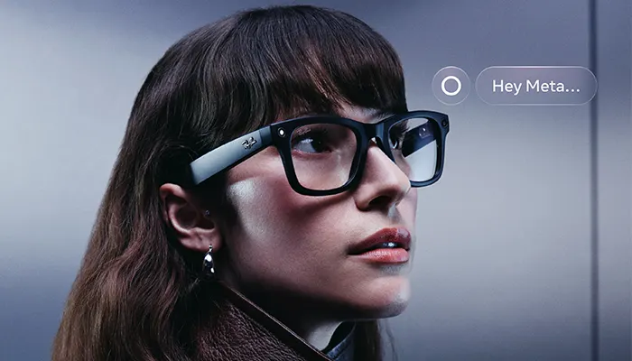 Donna dai capelli castani con un paio di occhiali ray-ban meta ed un prompt vicino "Hey meta.."