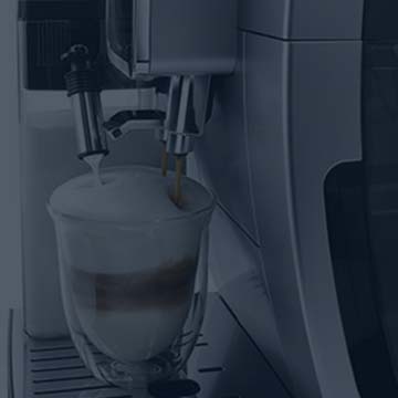 Macchina da caff� che eroga una bevanda in un bicchiere trasparente con strati distinti di colore chiaro e scuro.