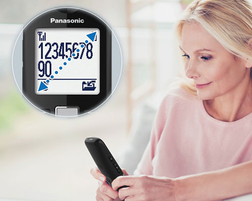 Donna con telefono Panasonic che mostra un display digitale con numeri e simboli su sfondo chiaro.