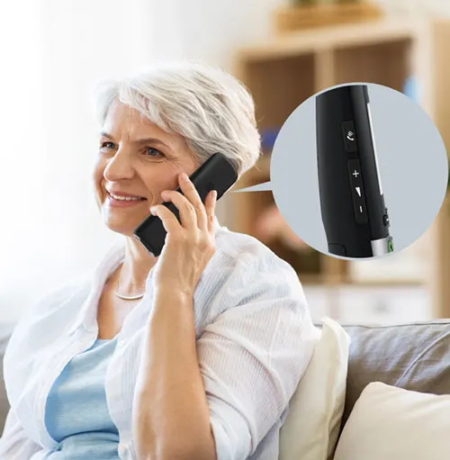 Donna sorridente parla al telefono nero seduta su un divano. Un cerchio mostra i pulsanti laterali del telefono.