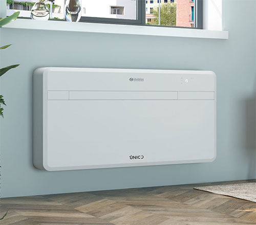 Unit� bianca di condizionamento montata a parete, sotto una finestra. Pavimento in legno e pianta visibili.