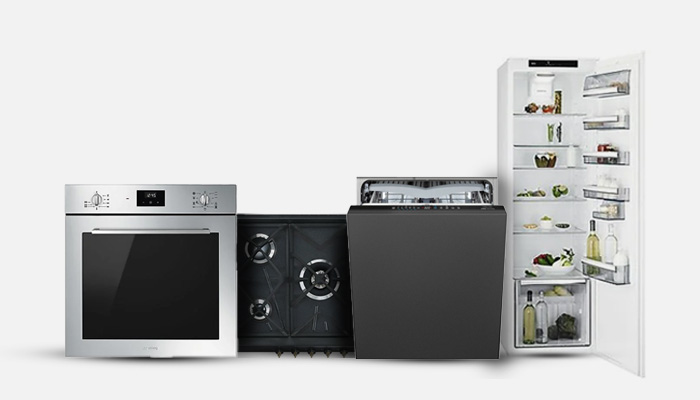 Forno in acciaio, piano cottura nero, lavastoviglie grigia e frigorifero bianco aperto con alimenti.