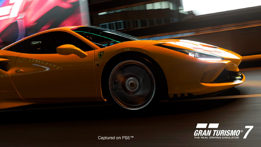 Coup� arancione su pista stradale illuminata, ruota in movimento. Insegna astratta rossa e blu sullo sfondo. Logo Gran Turismo 7 in basso.