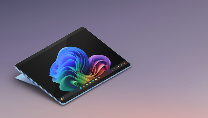 Un tablet su una superficie sfumata mostra uno schermo nero con un motivo astratto colorato.